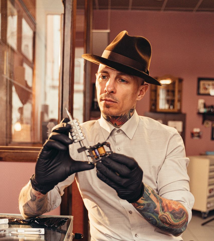 tattooer holding tattoogun 